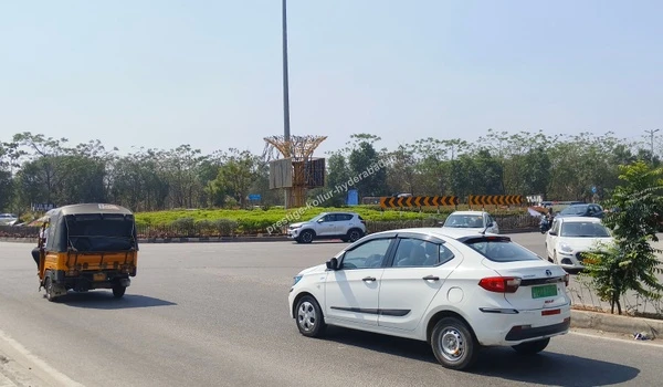 A bustling view of Active Roundabout Traffic featuring daily commuters and landscaped circles adjacent to the Nehru Outer Ring Road, showcasing the excellent road connectivity for future residents of Prestige Kollur Hyderabad as captured on March 03 , 2026.