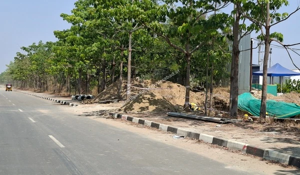 Roadside utility piping installation and materials staged along the boundary of Prestige Kollur in Kollur, Hyderabad