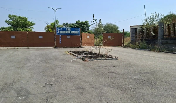 The closed entrance gates to the YNR Badminton Academy, highlighting the nearby sports and recreational amenities available in the location of Kollur, Hyderabad.