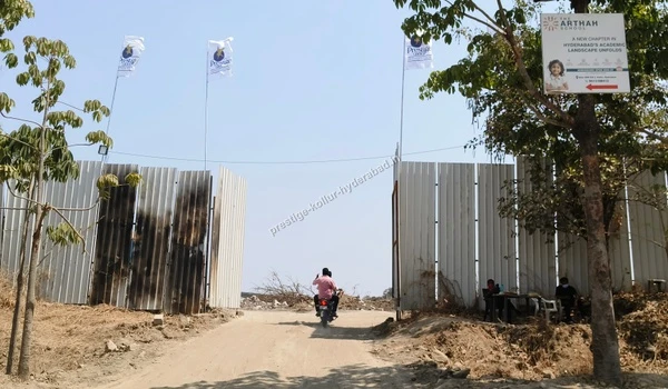 March 03 , 2026 - View of the main entrance gate setup under construction at the Prestige Kollur Hyderabad project site, showcasing the boundary wall installations near the Nehru Outer Ring Road for secure access.
